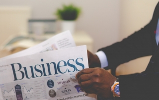 image of man in suit reading business page of newspaper