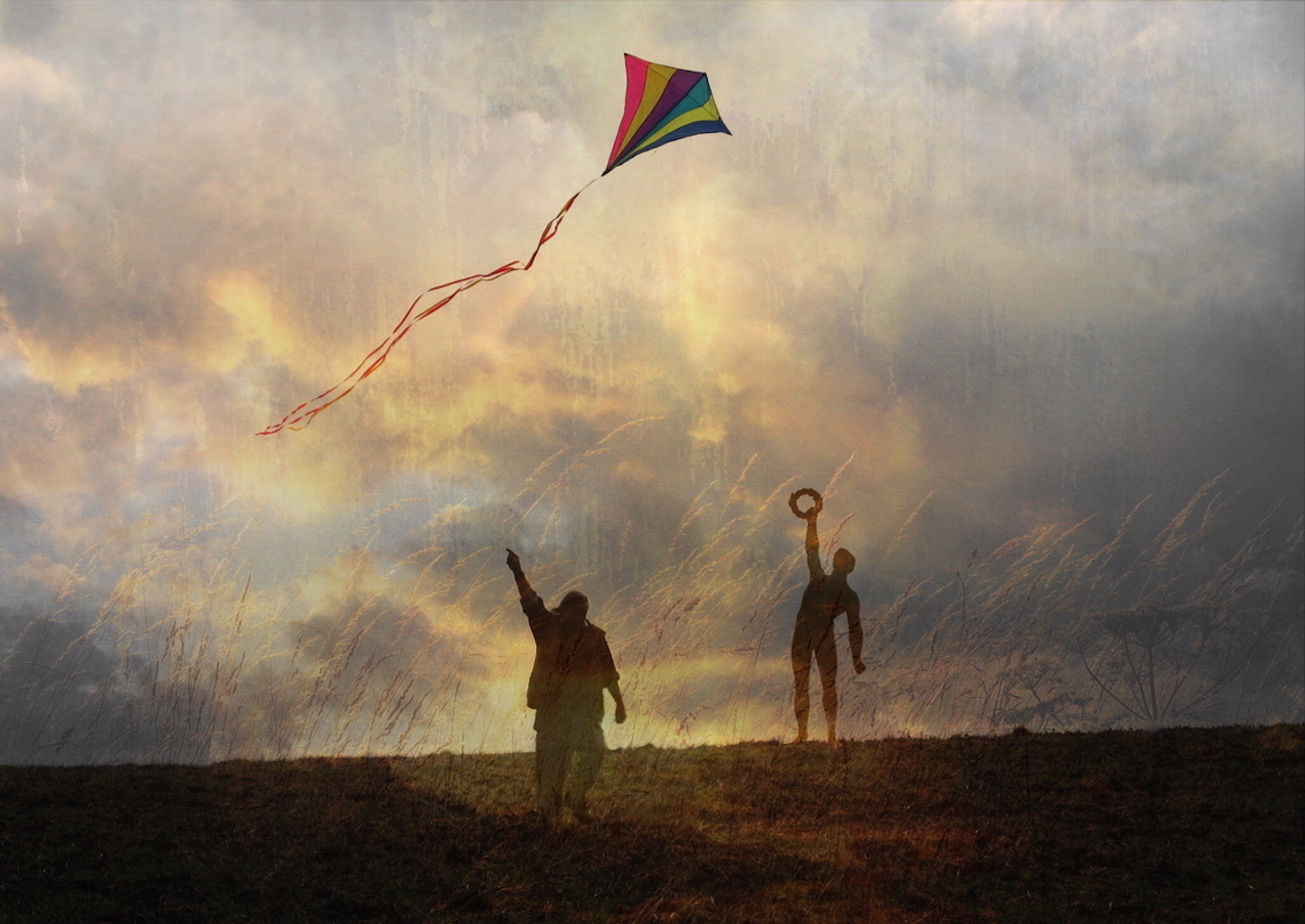 two people flying a kite at sunset