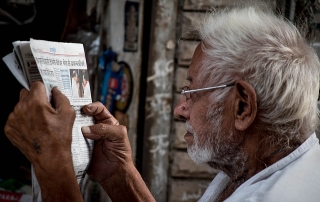 Elderly man reads a newsletter