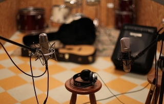 a stool with headphones on it placed between two microphones in a studio setting